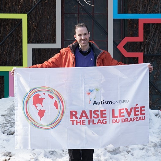 David Moloney tenant une affiche d’Autisme Ontario